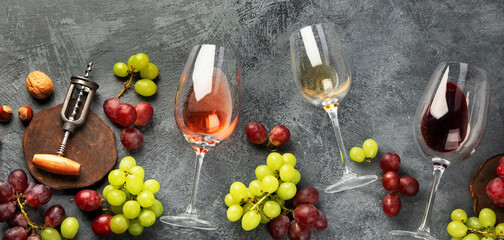 Different wine in glasses on gray background.