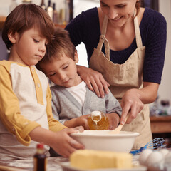 Moms little cake bosses. Two cute little boys baking with their mother in the kitchen.