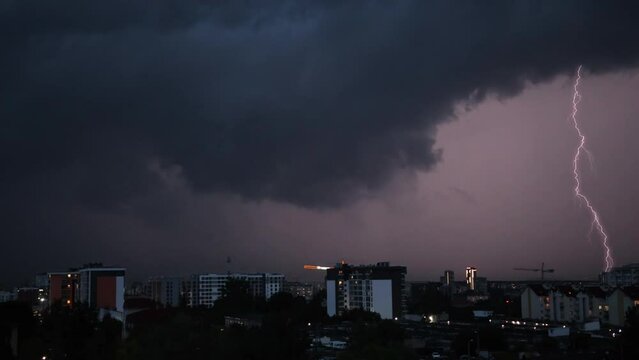 Concept on theme of weather, cataclysms hurricane, typhoon, tornado, storm. Lightning structure over the city sky. Low key lighting. Underexposed. Pink light