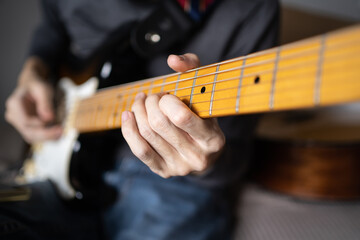 Left hand pressing strings on an electric guitar