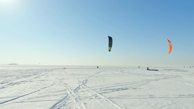 Snowkiting sportsmens in training.
Kitesurfing sport on the ice lake winter. 
