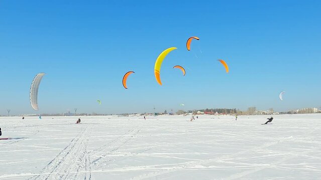 Snowkiting sportsmens in training.
Kitesurfing sport on the ice lake winter. 