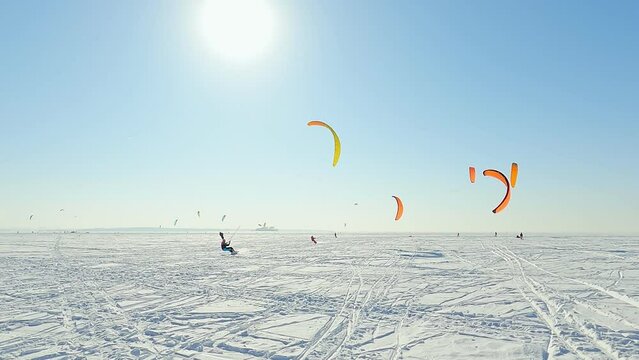 Snowkiting sportsmens in training.
Kitesurfing sport on the ice lake winter. 