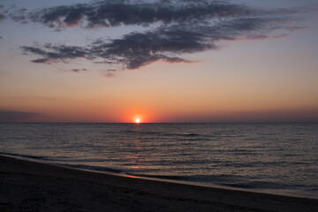 Beautiful sunset over sea with reflection in water, majestic clouds in the sky