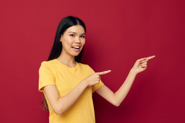 Portrait Asian beautiful young woman gestures with his hands in a yellow t-shirt casual wear studio model unaltered
