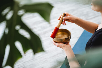 Tibetan bowl. Hands holding a bronze bowl hitting the stick extracts sound. Vibration for healing...