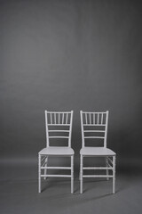 two white chairs on grey background