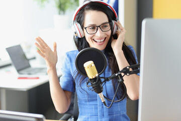 Female radio presenter in the studio at the microphone