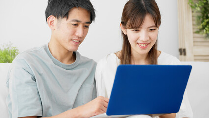 ノートパソコンを使う若い男性と女性