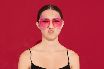 pretty woman pink glasses bright makeup posing black jersey pink background unaltered