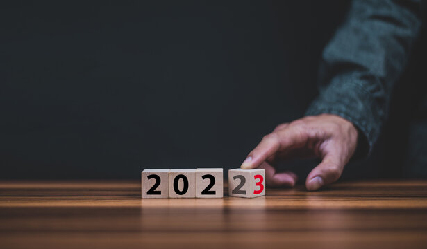Hand hold wooden cubes 2023 and 2023 concept business change to new success