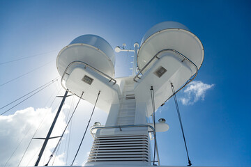 The mast of a large yacht with navigation equipment bottom view. Radar, signal lights, satellite...