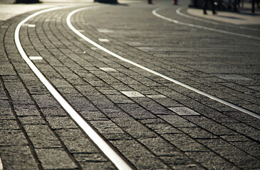 Cobblestone sidewalks of a city street in the evening of the setting sun