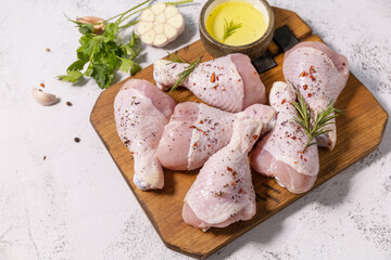 Chicken meat. Raw fresh chicken drumsticks with spices on a stone countertop. Copy space.