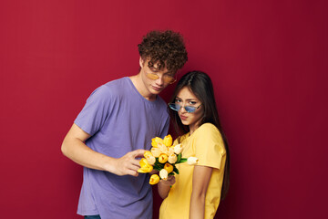 young boy and girl gift bouquet of flowers fun red background unaltered