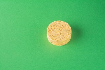 Podium of three round sponges for the face on a green background