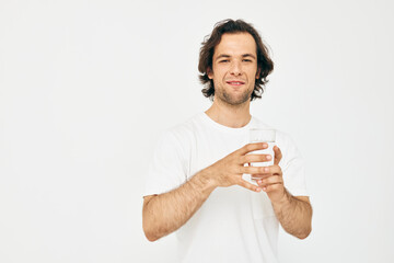 Attractive man in a white T-shirt glass of water isolated background