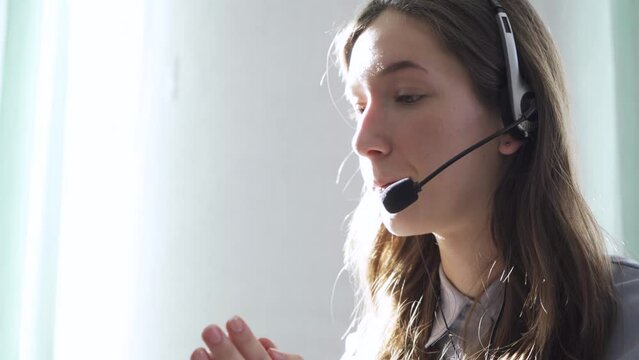 Serious call center operator in wireless headset talking with customer, close up