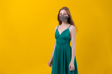Beautiful young woman protection mask wearing for coronavirus disease on yellow background in green dress with happy and cool smile on her face. Happy man.