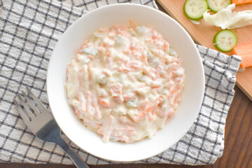 Creamy coleslaw salad in a white bowl.  Flat lay top view food photography.  Food from above.