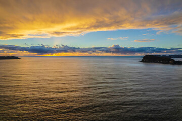 Obraz premium Aerial sunrise seascape with overcast sky and rain clouds