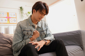 Asian man suffered a heart attack, resulting in chest pain and illness on the sofa.