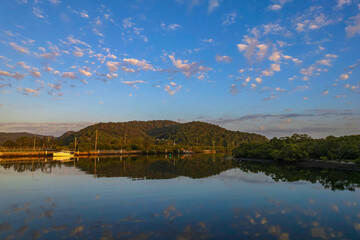 Sunrise waterscape with scattered clouds and reflections