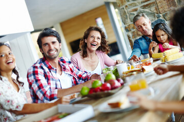 Enjoying mealtimes as a family. A happy family enjoying a meal time together.