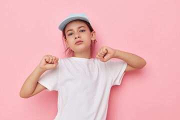 Portrait of happy smiling child girl posing white tshirt emotion pink background