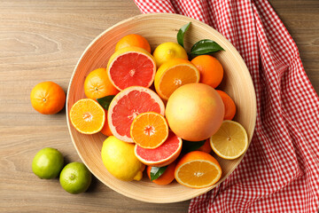 Different citrus fruits on wooden table, top view