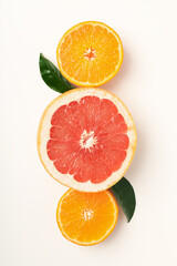 Citrus fruits with leaves on white background, top view