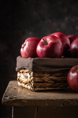Red apples in a basket on a dark background