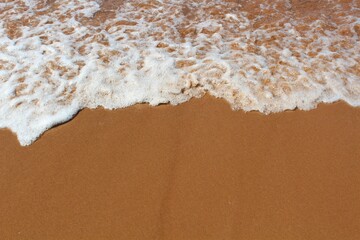 Texture of ocean water retreating over red sand typical of PEI, Canada