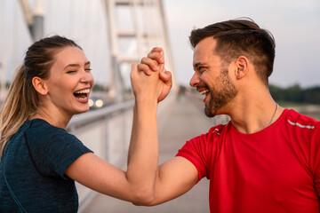 Early morning workout. Happy couple running across the bridge. Living healthy lifestyle.