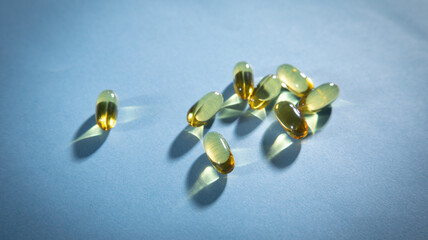 Fish oil Omega 3 capsules on the blue background.
