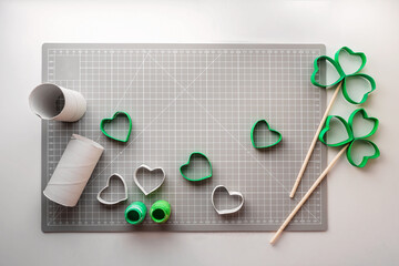 DIY paper clover with toilet roll tube on cutting mat for Saint Patrick Day celebration, zero waste...