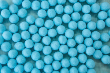 Soft fluffy ball as accessories for sewing production. Lots of blue objects.