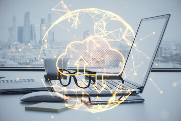 Close up of office workplace with laptop, other items, abstract glowing polygonal sphere with cloud...