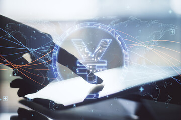 Close up of hand pointing at tablet with abstract glowing blue yen sign and map with charts on blurry background. Currency, trade and digital market concept. Double exposure.