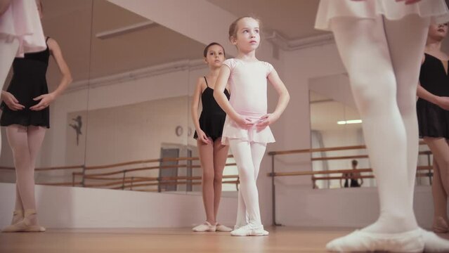 Ballet training - group of little ballerina girls standing in position in the studio