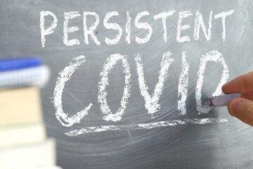 Persistent Covid concept. Hand writing on a blackboard.