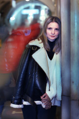 Obraz na płótnie Canvas young blond slavic woman with long hair in black leather jacket closeup photo on city undeground station background