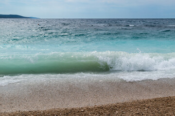 Wavy sea on the beach Zlatni rat near Bol town on the island of Brac in Croatia