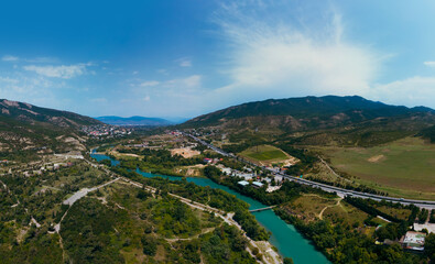 Fototapeta na wymiar A place where two rivers of different colors meet. Wide aerial view panorama. Mountains. Travel and vacation concept. Summer day. Tsitsamuri in Georgia.