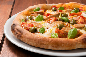 Deliziosa pizza gourmet con filetti di tonno pinna gialla, olive, pomodorini, mozzarella, cipolla e basilico 