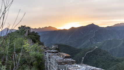 Bergpanorama an der chinesischen Mauer: die aufgehende Morgensonne färbt das Tal sowie die Steine...