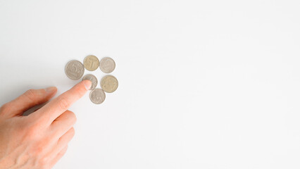 Financial problems, crisis, falling value of money, poverty, poor concept. Top view man counting money russian ruble coins on white table. Banner, copy space