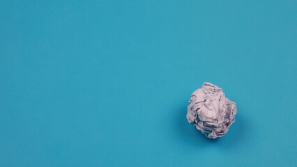 Close-up of junk white crumpled paper on blue background. Rcycling concept