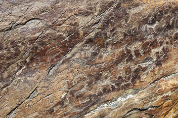 Drawn figure animals and hunter on the stone wall. Rock painting in Karakol Ethno-natural Park Uch Enmek, Altai Republic, Russia. Historical heritage in Karakolskaya valley.
