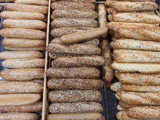 Variety of different types of French baguettes in a bakery or grocery store. Freshly baked bread